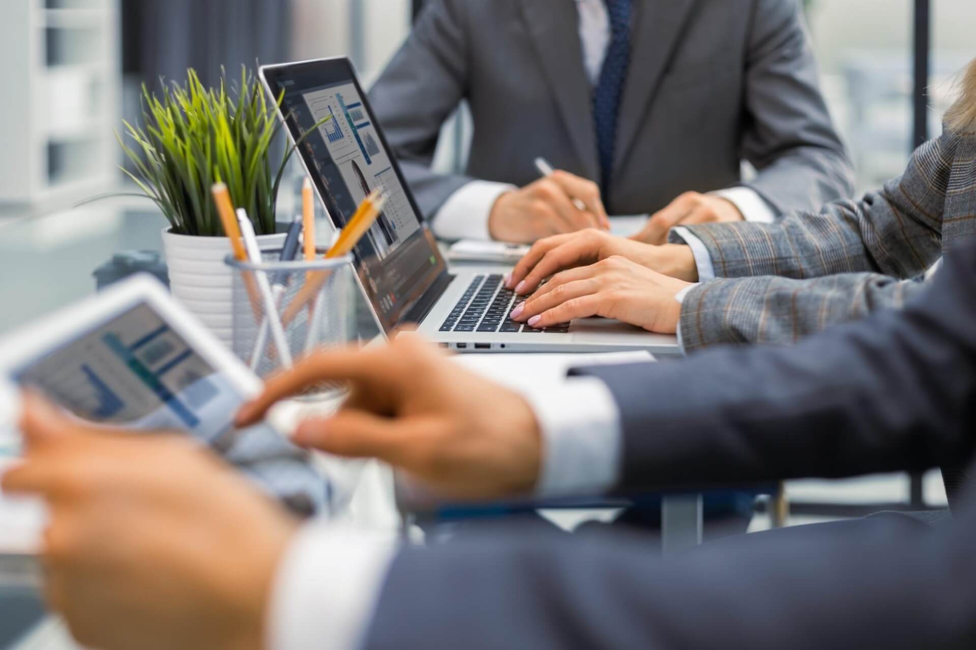 The market research process being carried out by multiple experts using various tools in a collaborative office environment.