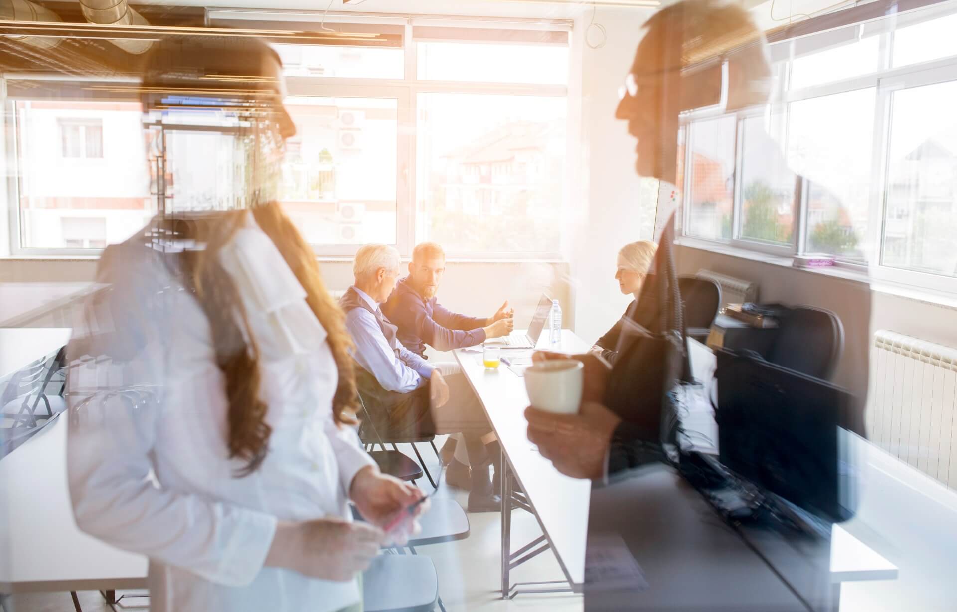 Enhancing Executive Effectiveness in Large Corporations: Key Success Drivers 2 Business meeting with corporate executives in a modern office, discussing executive effectiveness in large corporations. Reflections on glass surfaces create a dynamic and innovative atmosphere.
